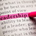 The word Leadership being highlighted in a book by a marker