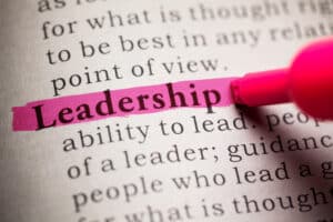 The word Leadership being highlighted in a book by a marker